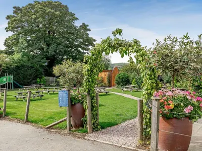 a garden with potted plants and tables and benches at Daffodil - Uk40266 in Llangadfan