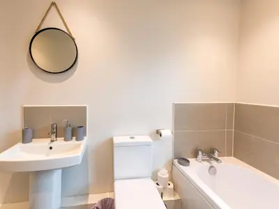 a bathroom with a sink and a toilet and a mirror at Perfectly located 2 bed townhouse in Shrewsbury - Pass the Keys in Shrewsbury