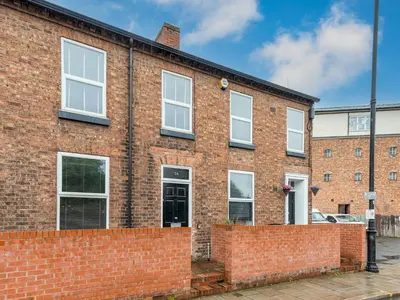a brick building with white windows and a brick wall at Perfectly located 2 bed townhouse in Shrewsbury - Pass the Keys in Shrewsbury