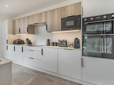 a kitchen with white cabinets and black appliances at Jacobs Plock in Leintwardine