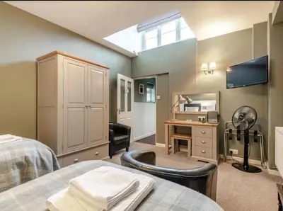 a room with a bed and a desk and a mirror at Curly Tail Accommodation in Bishops Castle