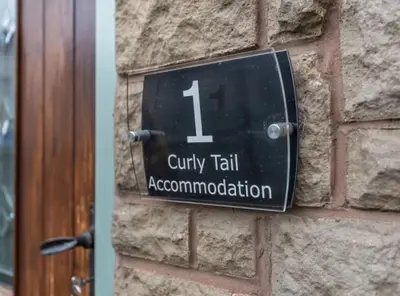 a clock on the side of a brick wall at Curly Tail Accommodation in Bishops Castle