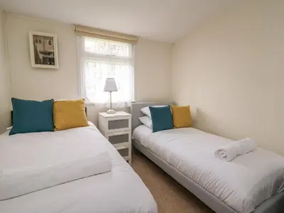 two beds in a small room with a window at Chalet 64 in Tywyn