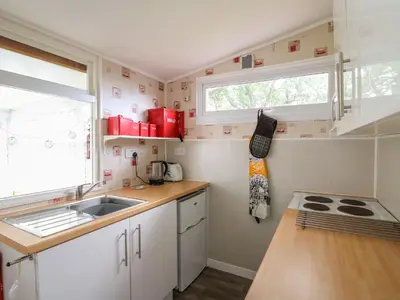 a small kitchen with a sink and a window at Chalet 64 in Tywyn