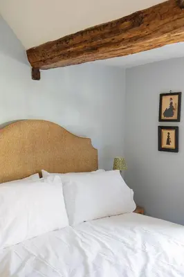 a bedroom with a white bed with a wooden ceiling at Ludlow Townhouse in Ludlow