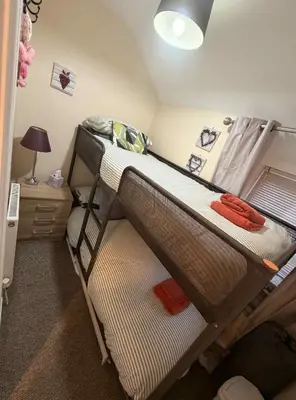 two bunk beds in a small room with a lamp at Hill View Cottage in Bala