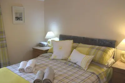 a bedroom with a bed with towels on it at Hill View Cottage in Bala