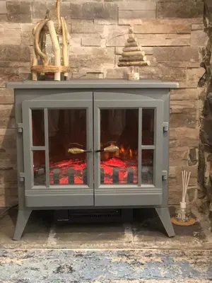 a fireplace in front of a stone wall at Ty Cwtch in Dolgellau