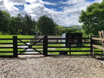a wooden fence in front of a field at Shepherds Hut at The Retreat in Oswestry