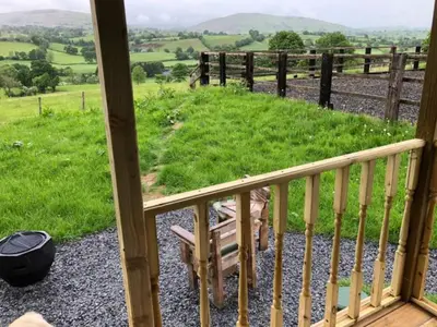 a balcony with a view of a grassy field at Shepherds Hut at The Retreat in Oswestry