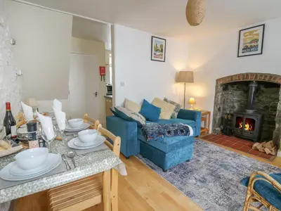 a living room with a blue couch and a fireplace at Rowan Cottage in Builth Wells
