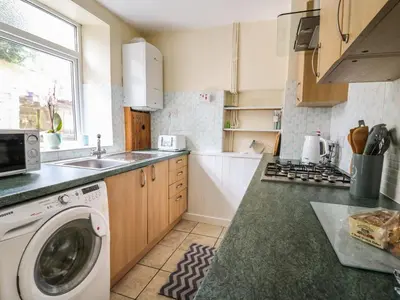 a kitchen with a washing machine and a sink at Rowan Cottage in Builth Wells