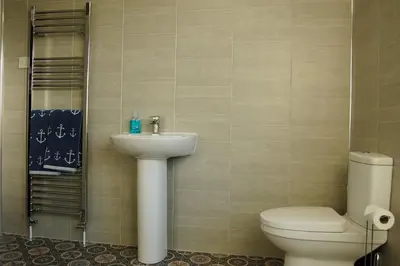 a bathroom with a toilet and a sink at Angorfa family holiday home with games room in Tywyn