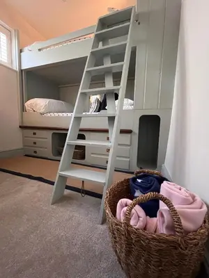 a bunk bed with a ladder and a basket at Efail Fach in New Quay