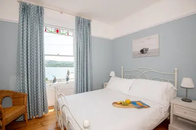 a bedroom with a bed with a plate of fruit on it at Loyalty in New Quay