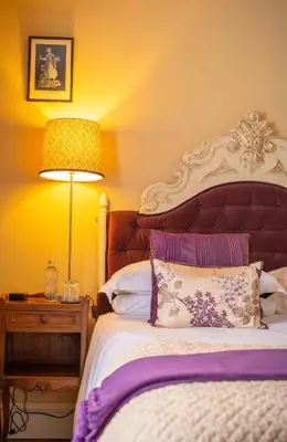 a bedroom with a large bed with a lamp and a bed sidx sidx sidx sidx at The New White Lion in Llandovery