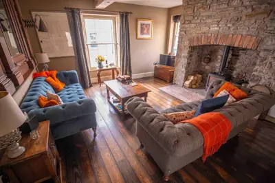 a living room with two couches and a stone fireplace at The New White Lion in Llandovery
