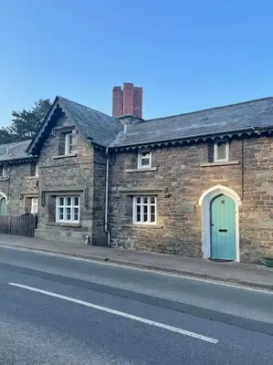 a brick house with a green door on a street at Yew Tree Cottage, 3 bedroom, 4 Church Row Defynnog in Devynock