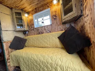 a bedroom with a couch in a tiny house at Ty Gwenyn, Coity Bach in Brecon