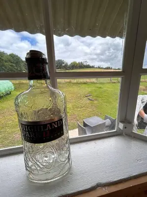 a bottle of alcohol sitting on a window sill at Ty Gwenyn, Coity Bach in Brecon