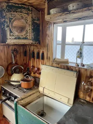 an old kitchen with a stove and a window at Ty Gwenyn, Coity Bach in Brecon