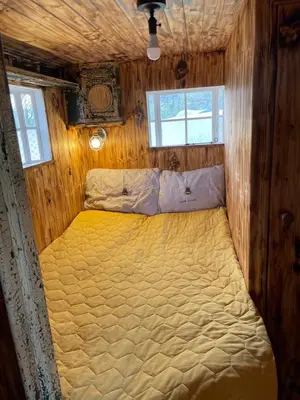 a bedroom with a bed in a wooden room at Ty Gwenyn, Coity Bach in Brecon
