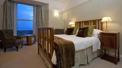 a bedroom with a large bed and a large window at Wavecrest in Barmouth
