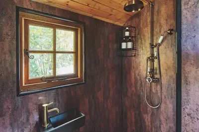 a bathroom with a shower and a sink and a window at Big Sky Hideaway in Leominster