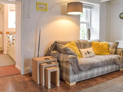 a living room with a couch and a table at Penlan Cottage in Cwrt-newydd