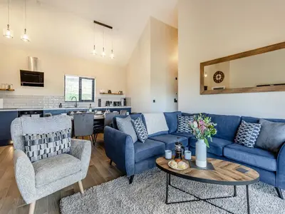 a living room with blue couches and a table at The Lara - Uk45019 in Mochdre