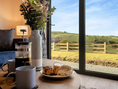 a table with a plate of food and a window at The Lara - Uk45019 in Mochdre