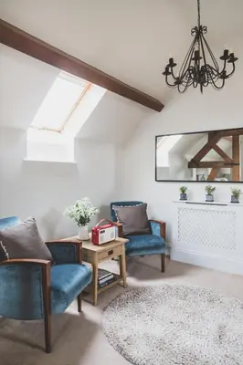 a living room with two blue chairs and a table at The Clive Arms in Ludlow