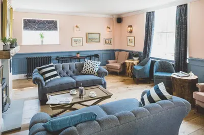 a living room with blue couches and a table at The Clive Arms in Ludlow