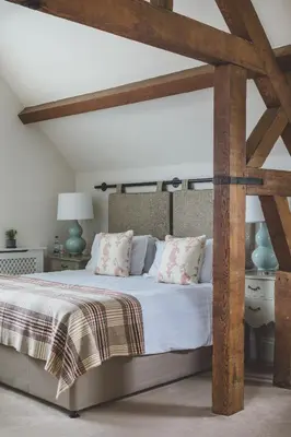 a bedroom with a large bed with wooden beams at The Clive Arms in Ludlow