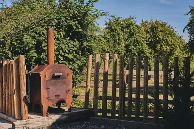 a wooden fence with a brick oven in front of a gate at Curious Calf in Leominster