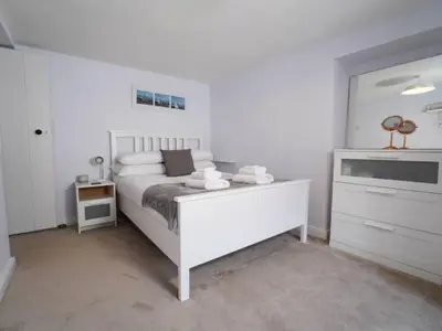 a white bedroom with a bed and a dresser at Characterful 3 Bedroom Cottage in Aberystwyth