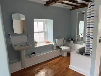a bathroom with a sink and a toilet and a window at Characterful 3 Bedroom Cottage in Aberystwyth