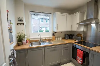 a kitchen with white cabinets and a sink and a window at Relaxing Town Centre House - Perfect for Exploring in Shrewsbury