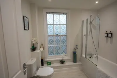 a bathroom with a toilet and a shower and a window at Relaxing Town Centre House - Perfect for Exploring in Shrewsbury