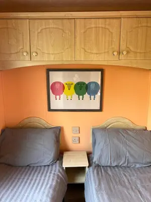 a bedroom with two beds and a picture of birds at Holiday Home by the sea in Aberystwyth