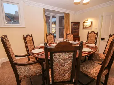 a dining room with a wooden table and chairs at Dinham Court in Ludlow