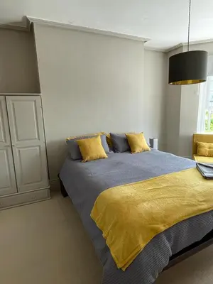 a bedroom with a large bed with a yellow blanket at Northampton House in Llanwrtyd Wells