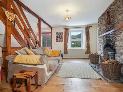 a living room with a couch and a fireplace at Delfryn, Goginan in Aberystwyth