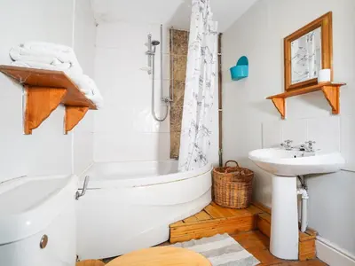 a bathroom with a white tub and a sink at Delfryn, Goginan in Aberystwyth