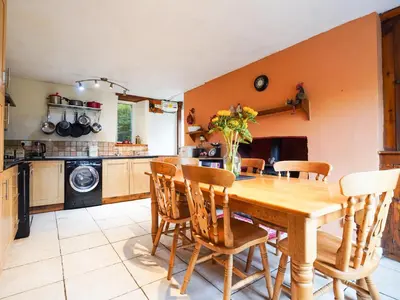 a kitchen with a wooden table and chairs at Delfryn, Goginan in Aberystwyth