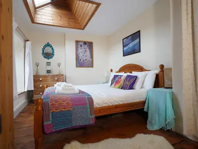 a bedroom with a bed with a wooden headboard at Delfryn, Goginan in Aberystwyth