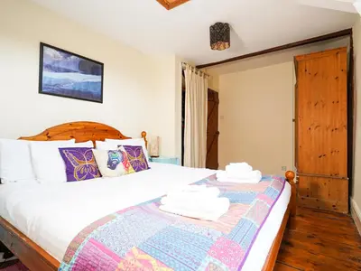 a bedroom with a large bed and a window at Delfryn, Goginan in Aberystwyth