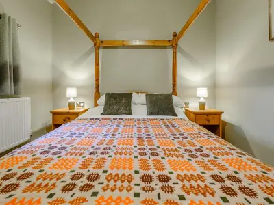 a bedroom with a bed with a colorful bedspread at Maesyrhaf in Llanllwchaiarn