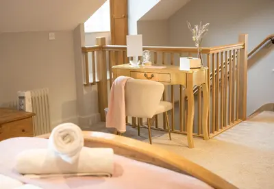 a room with a desk and a chair and a table at Vineyard Country Cottage in Llanerch-Aeron