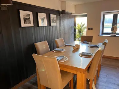 a dining room with a wooden table and chairs at Penestaer in Machynlleth
